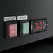 A close-up of the black digital thermostat screen on an Avantco merchandising refrigerator.