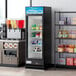 An Avantco merchandising refrigerator with shelves full of beverages.