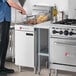 A man standing in front of a Wolf liquid propane floor fryer.