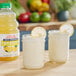Two jars of Dr. Smoothie 100% Crushed Lemonade Smoothie Mix with lemons and a glass of lemonade.