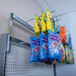 A Retail Space Solutions Magna-Bar vertical extension kit holding a yellow bag of candy on a shelf.