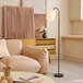 A living room with a couch and a Globe Lofty Chic floor lamp with adjustable gooseneck.