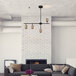 A Globe modern matte black and brass track light in a living room with a couch and fireplace.