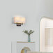 A Globe matte black wall sconce with a rectangular white linen shade on a wall.