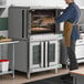 A double deck full size electric convection oven with glass doors, shown in a commercial kitchen setting.