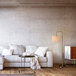 A Globe brass floor lamp with a white lamp shade next to a white couch.