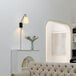 A Globe Lofty Chic Matte Black Wall Sconce with a white shade and swing arm on a white wall above a couch.