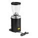 A black Mahlkonig E65T commercial coffee grinder on a table.