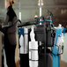 A woman using a Toolflex black canister holder on a cleaning cart.