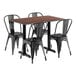 A Lancaster Table & Seating rectangular textured walnut table with black metal chairs.