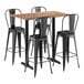 A Lancaster Table & Seating rectangular wood bar table in Yukon Oak with black metal legs and 4 black metal barstools.