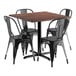 A Lancaster Table & Seating square wooden table with black metal chairs around it.