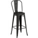 A black metal bar stool with a backrest.