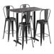 A Lancaster Table & Seating black metal bar table with four black barstools.