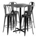 A Lancaster Table & Seating black metal bar table with 4 black Alloy Series barstools.