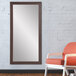 A BrandtWorks espresso finish mirror sitting against a wall.