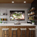 A bar with a white counter and white bar stools with black legs and a large canvas of a tray with tequila shots.