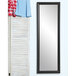 A BrandtWorks modern matte black mirror on a white wall with a shirt hanging on it.