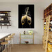 A canvas wall art print of two champagne glasses on a table with a bottle of champagne.