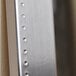 A close-up of a BrandtWorks embossed metal frame with a silver finish.