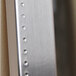 An embossed stainless steel mirror frame with holes.