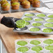 A hand in a black glove holding a green pistachio muffin.