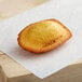 A St. Michel Citrus Madeleine pastry on a white paper.