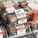 A person holding a package of Nats Rawline Plant-Based Vegan Caramel and Chocolate Raw Cakes.