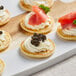 A group of Le Chic Patissier mini blinis topped with cream cheese and fish.