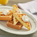 A plate of Le Chic Patissier custard cream-filled waffles with whipped cream on top.