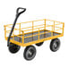 A yellow heavy-duty steel utility cart with four large wheels and a black handle.