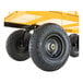 A close-up view of the wheels and part of the yellow steel frame of a heavy-duty utility cart.