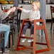 A man and a child in a Lancaster Table & Seating wooden high chair.