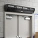 A black rectangular Boltic air curtain with a vent above a door.