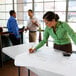 A woman writing on a white Lifetime folding table.