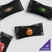 A group of black plastic bags with custom labels in different colors.
