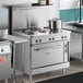 A large commercial kitchen with a Cooking Performance Group stainless steel 6-burner electric range.