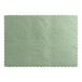 A sage green paper placemat with scalloped edges.