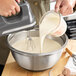 A person mixing Eclipse Foods vegan ice cream mix in a bowl with a whisk.