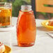 A Classic Queenline PET inverted bottle filled with honey on a table.
