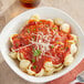 A bowl of pasta with RedPack tomato sauce and cheese on top.