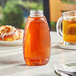 A close-up of a 12 oz. Honeycomb PET inverted honey bottle on a table.