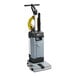 An Advance SC100 upright floor scrubber with a yellow wand and hose attached.