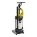 An Advance SC100 walk behind floor scrubber with a yellow cord and wand.