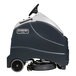 An Advance SC1500 stand-on floor scrubber machine with wheels.
