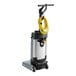 An Advance SC100 corded upright walk behind floor scrubber with a yellow tube.