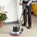 A person using an Advance Pacesetter floor cleaning machine to polish the floor.