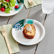 A Choice medium weight paper plate with a fork and a piece of cake on it.