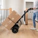 A person using a Gorilla steel hand truck to move boxes.