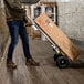 A man pushing a Gorilla convertible hand truck with a box.